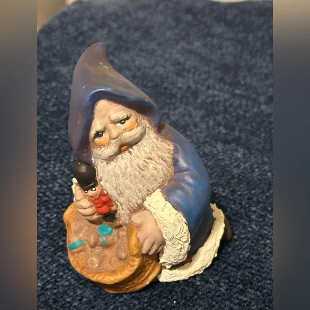 Cute blue robed kneeling Santa. He carries a basket of gifts.